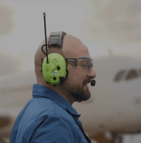 Ground crew wearing aviation headset near aircraft